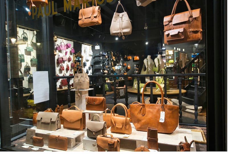 Independent leather goods boutique window display featuring curated handbag collection