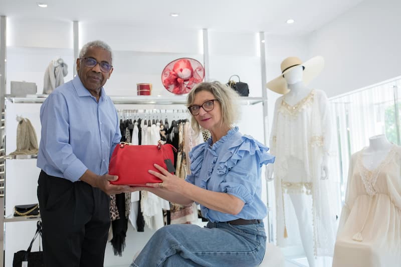 Independent boutique buyer walking a trade show aisle evaluating wholesale handbag lines