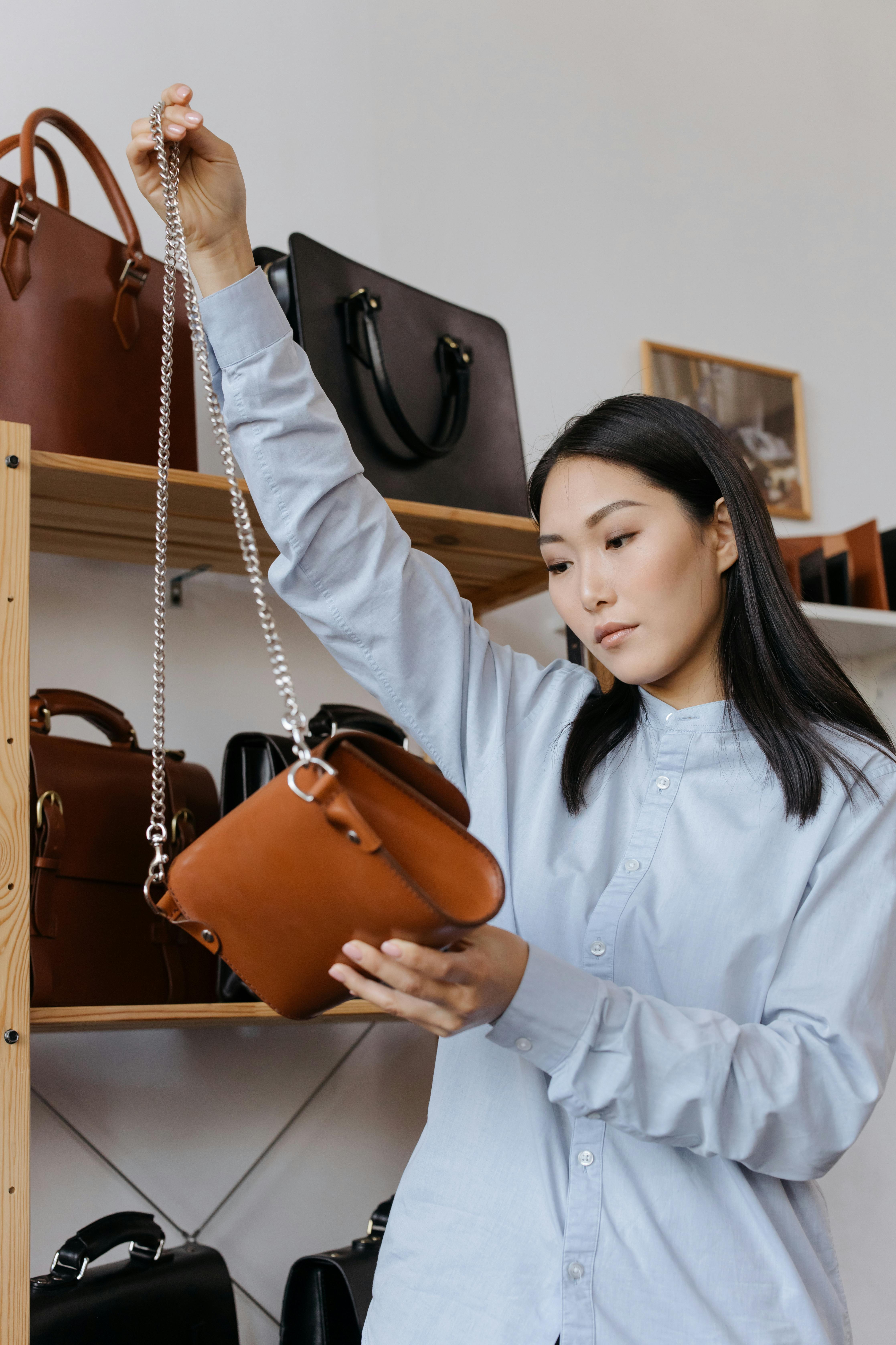 Creator inspecting a chain strap handbag before launching her private label brand