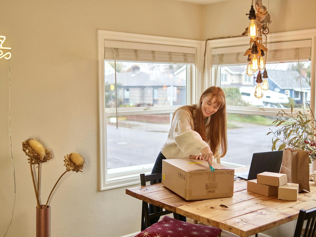 Creator smiling as she opens a shipment of bags — ready to prepare her next TikTok bag drop
