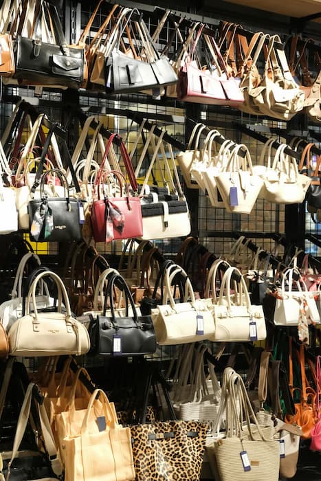 Stacked wholesale handbag catalogs on a boutique buyer's counter